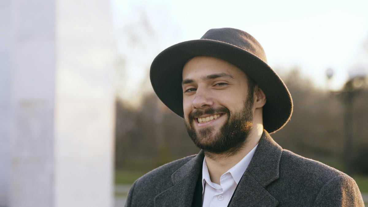 Man in a grey felt hat and wool coat outdoors